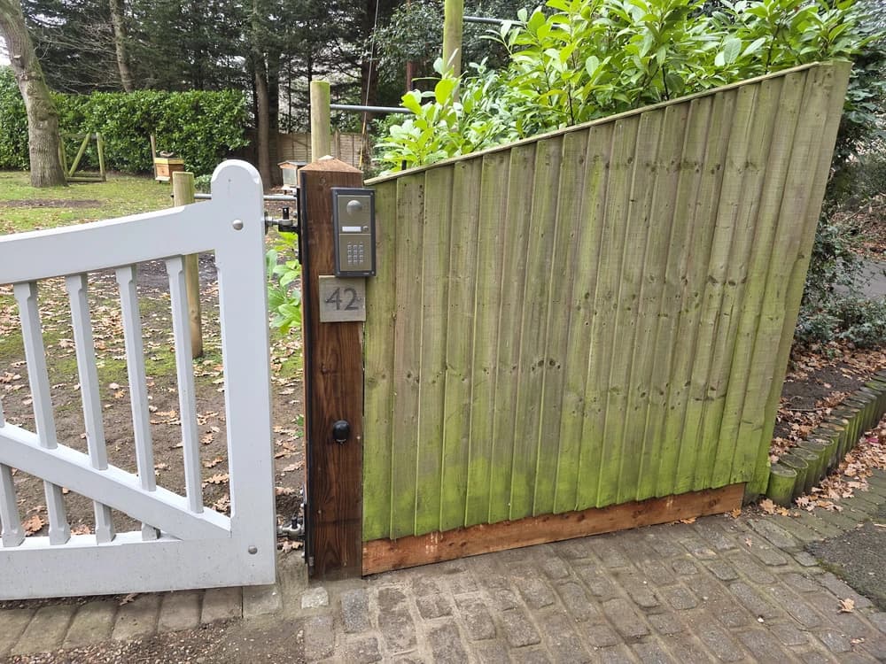 White picket gate with an intercom mounted on the post