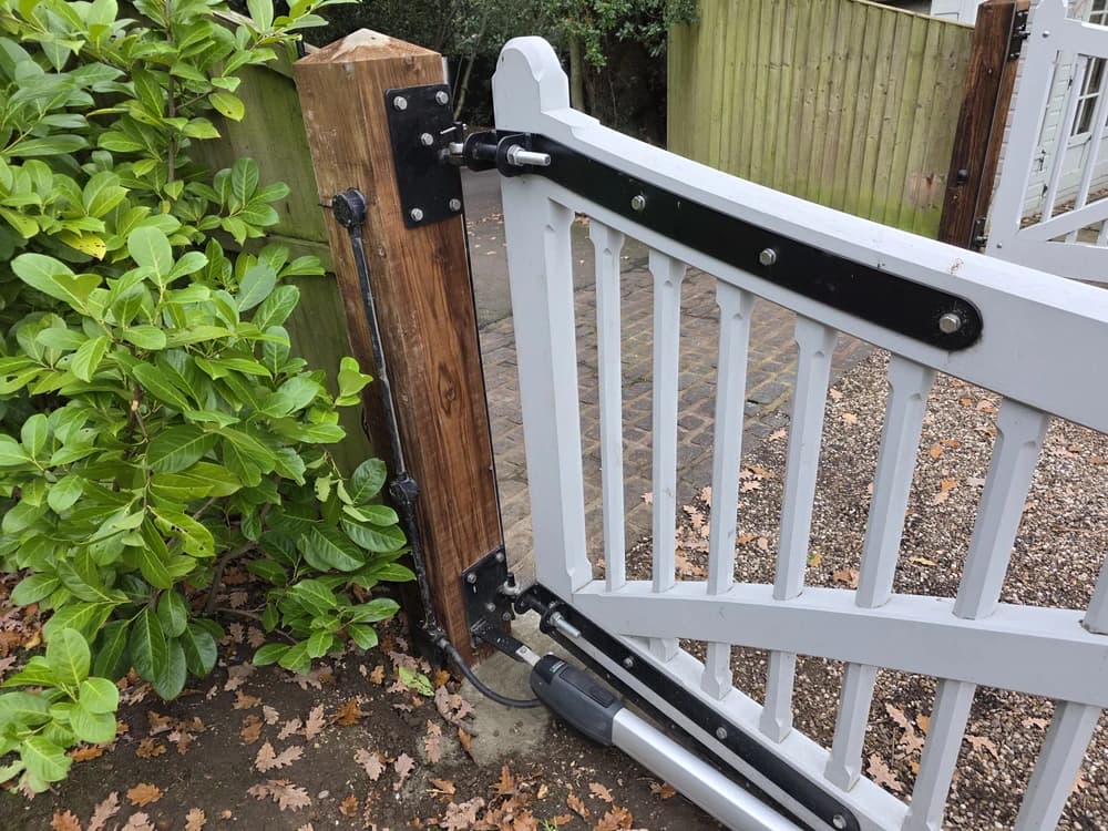 Automation ram detail on a white picket gate