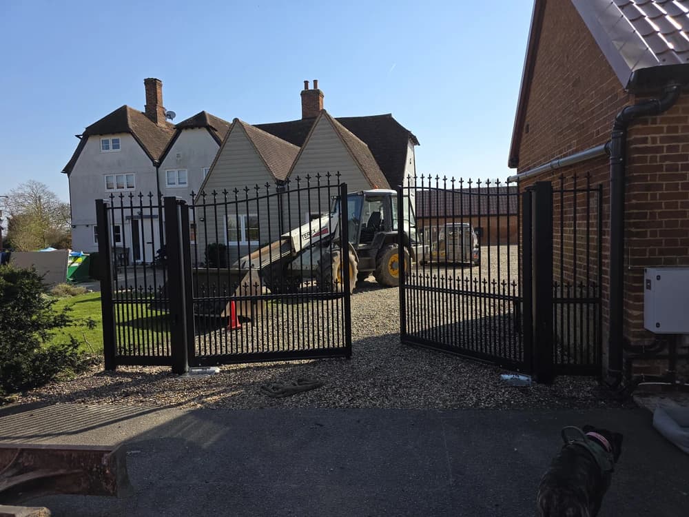 Black metal spear-top estate gates outside a farmhouse