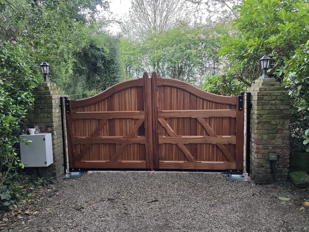 Hardwood swan-neck gates hung between brick pillars