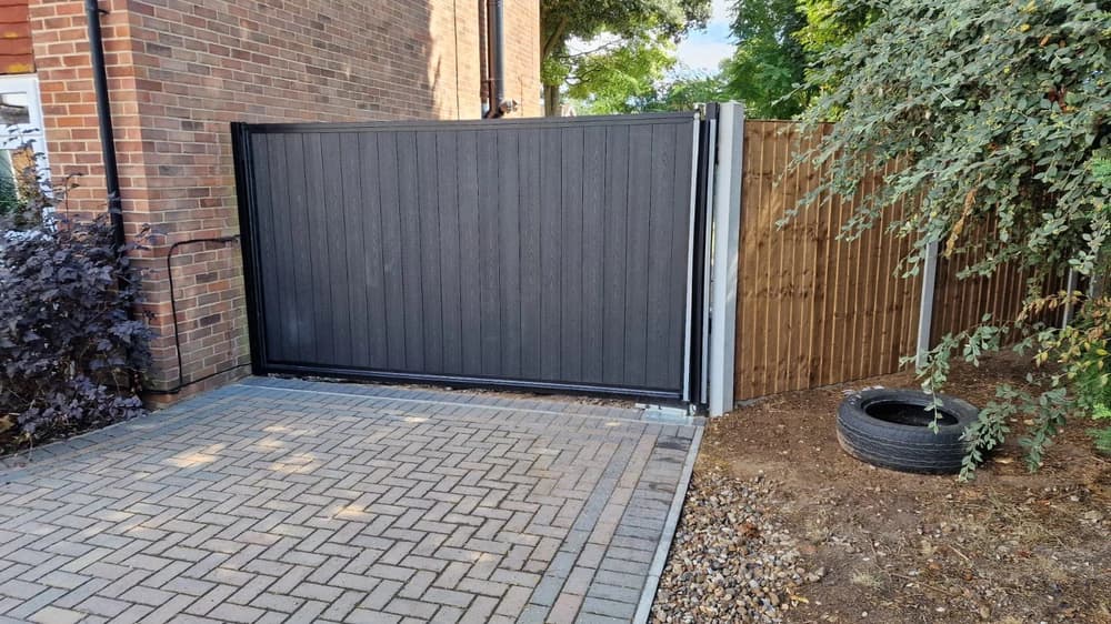 Grey composite slatted sliding driveway gate