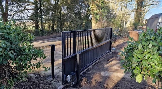 Black metal vertical-bar sliding gate with automation